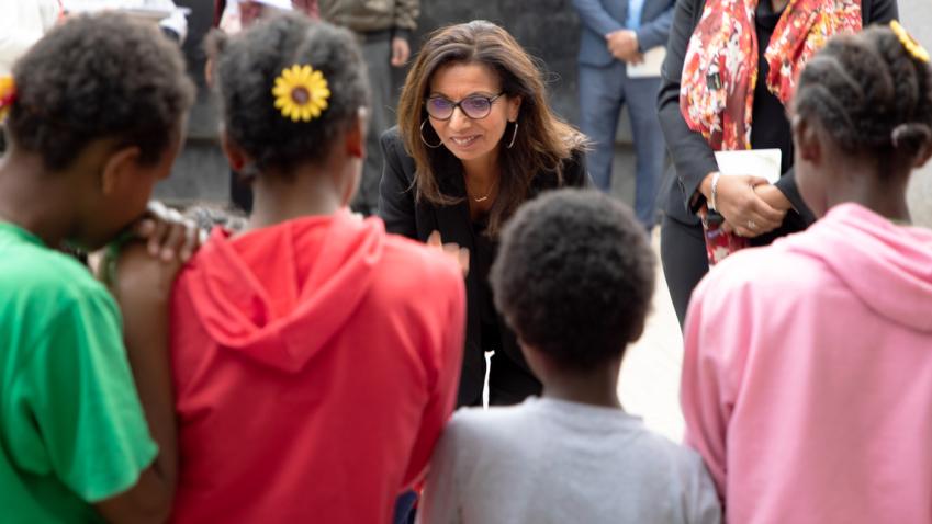 Najat leans into a group of children