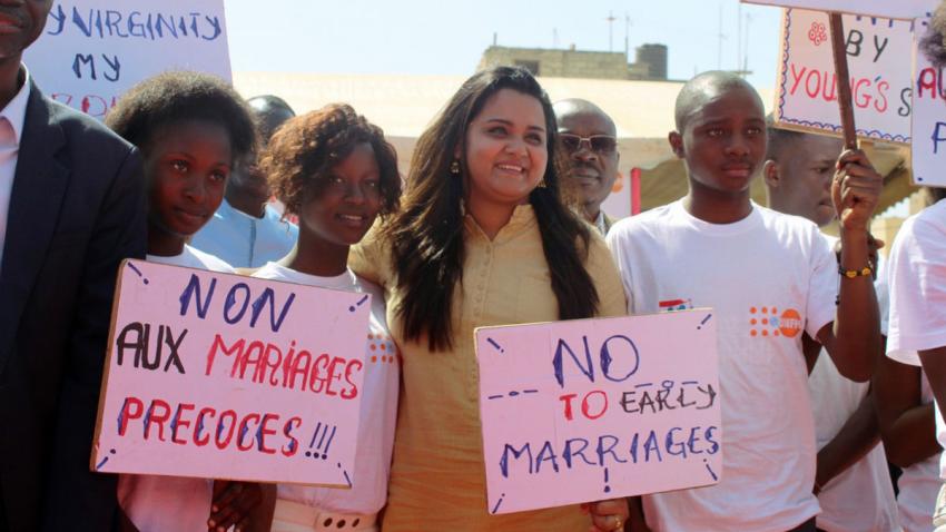 Jayathma walks in a procession with many people all holding signs that ready 'no to early marriage'