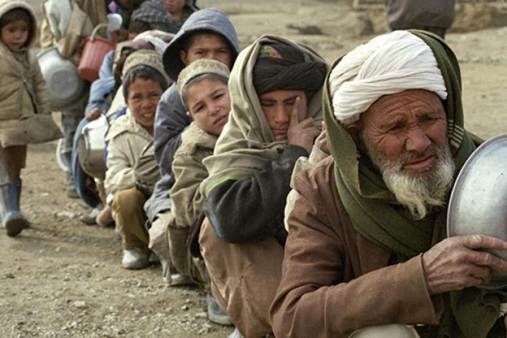 A group of internally displaced persons in Afghanistan seated in a row.