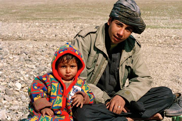 Father and young child sitting on the ground