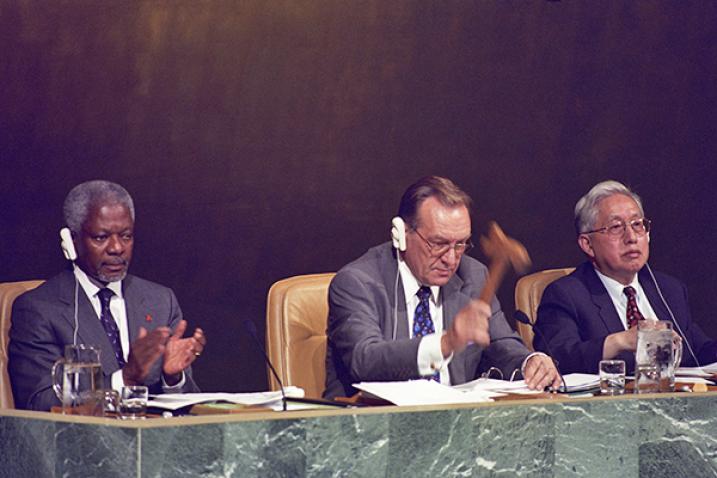Three men on General Assembly podium: S-G Kofi Annan is at left. GA President Harri Holkeri is center. USG Jin Yongjian is at right.