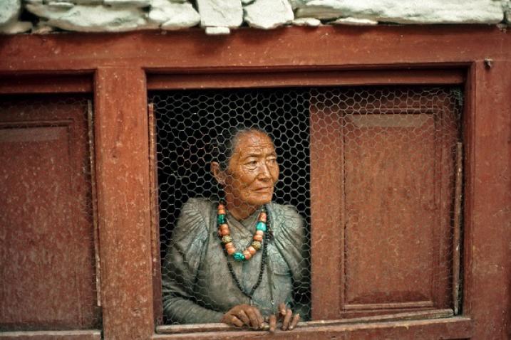 Une femme âgée à sa fenêtre au Népal.
