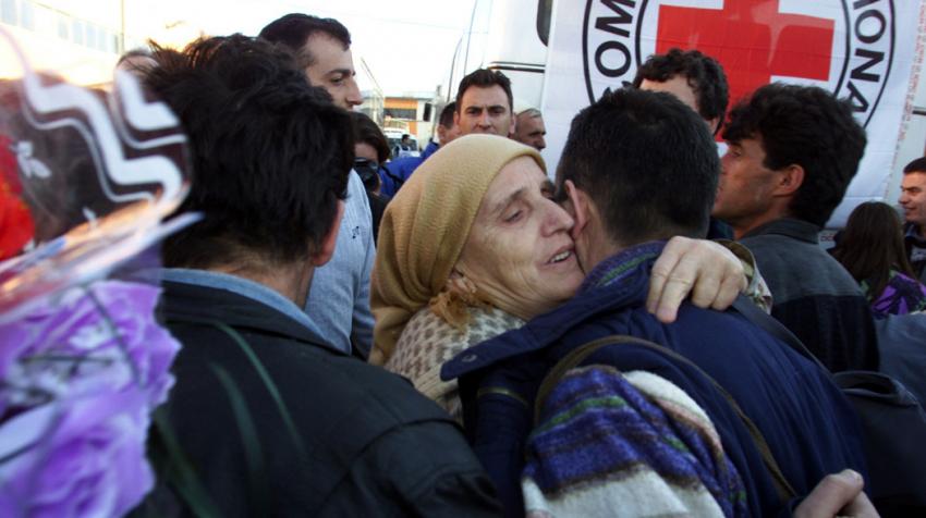 A woman hugging a man, who reunited with his family. 