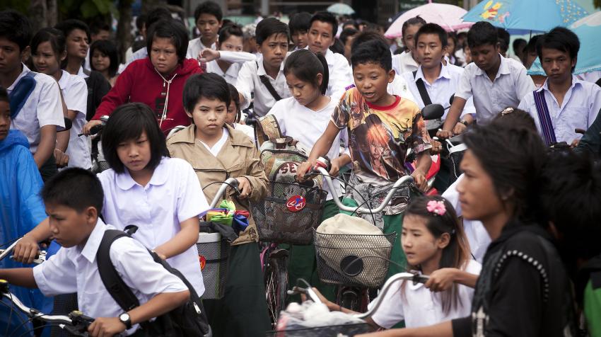 В Тачилеке, Мьянма, толпа учеников возвращается домой после утренних занятий в городской начальной школе, которая вынуждена работать в несколько смен из-за нехватки учебных помещений. 2011 год, Фото ООН/Кибэ Парк