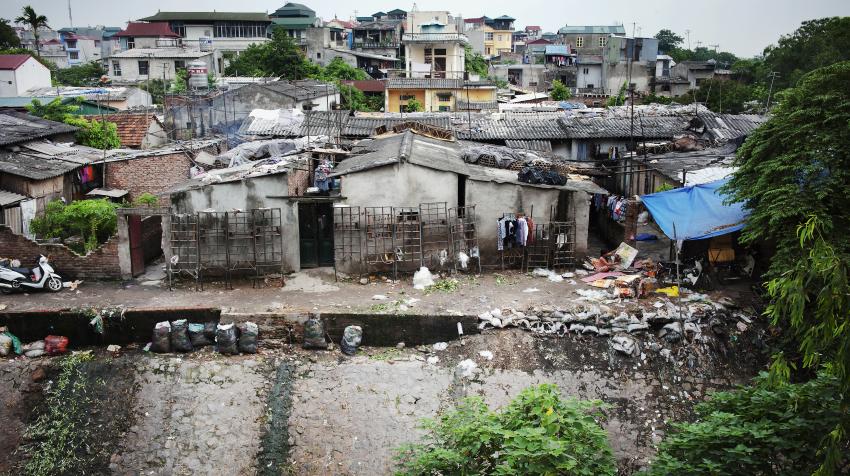 越南河内的一个城市贫民窟。根据世界银行的数据，13%以上的越南人口和25%的世界人口（共近20亿人）每天的生活费为1.25美元或以下，摄于2011年。联合国图片/Kibae Park