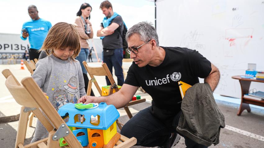UNICEF Rep in Ukraine Murat and child at a centre in Zaporizhzhia. 24 May 2022. UNICEF/Kate Klochko