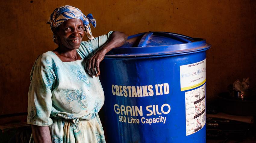 Ketty Okello, 64, with her grain silo in Apac, Uganda. She says that the silo, provided by FAO, has increased her income and helped her better care for her harvests. 26 September 2020. © FAO/Sumy Sadurni