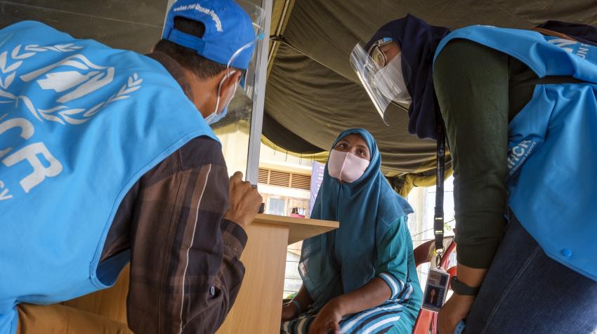 Rohingya refugee Abu Ahmed (left), works as a translator helping UNHCR staff member Dini Hasdianti (right) register a fellow Rohingya refugee from Myanmar at a government complex in Lhokseumawe, Aceh province, Indonesia, 18 September 2020. ©UNHCR/Jiro Ose
