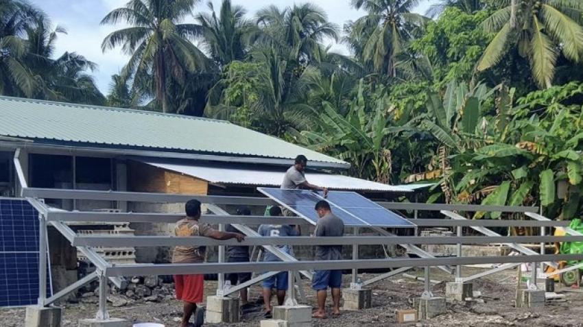 Des hommes installent des panneaux solaires aux Palaos. L’énergie renouvelable peut jouer un rôle crucial pour le pays. Photo : Ministère de l’éducation des Palaos.