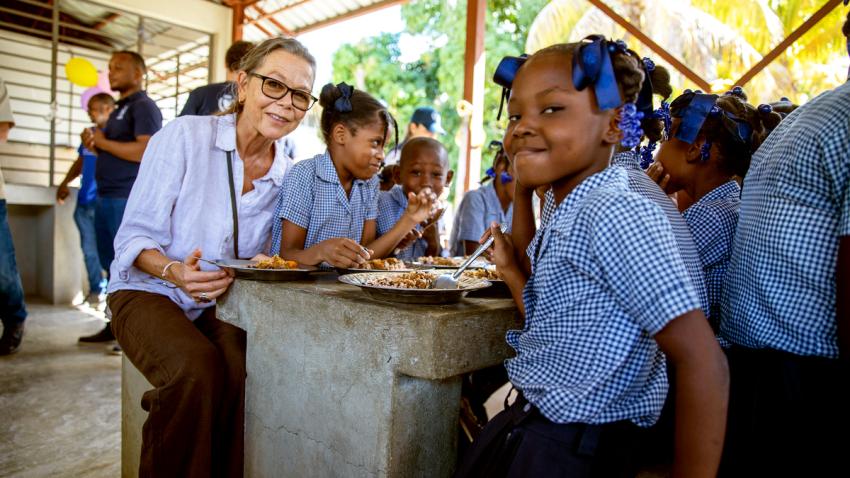 Ulrika Richardson is seated at a table as she shares a meal with schoolchildren