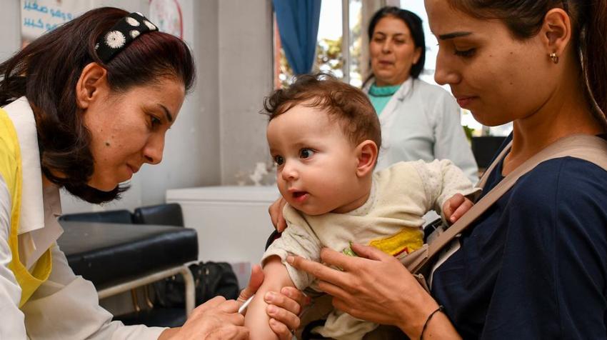 UNICEF/Johnny Shahan. Un enfant de huit mois reçoit ses vaccins contre la polio et la rougeole.