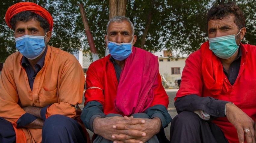 FMI Photo/Saiyna Bashir. Des hommes sont assis sur le trottoir au Pakistan en attendant d'être embauchés pour travailler.