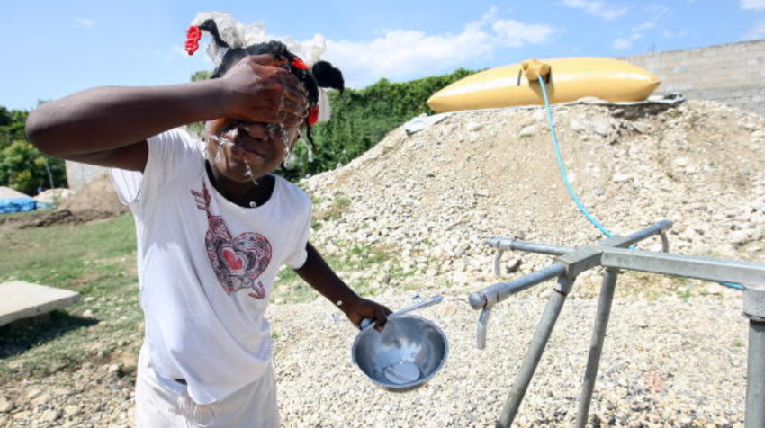 Sophia Paris/A young girl washes her face in Croix des Bouquets, Haiti.