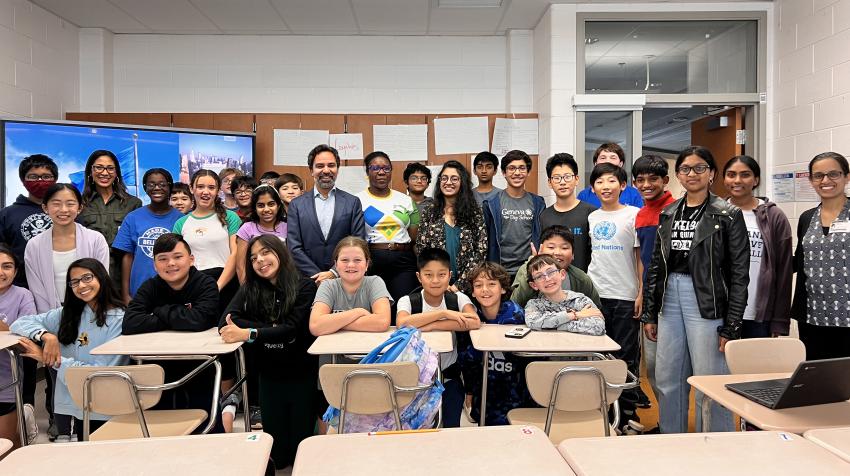 UN official poses with students in a classroom