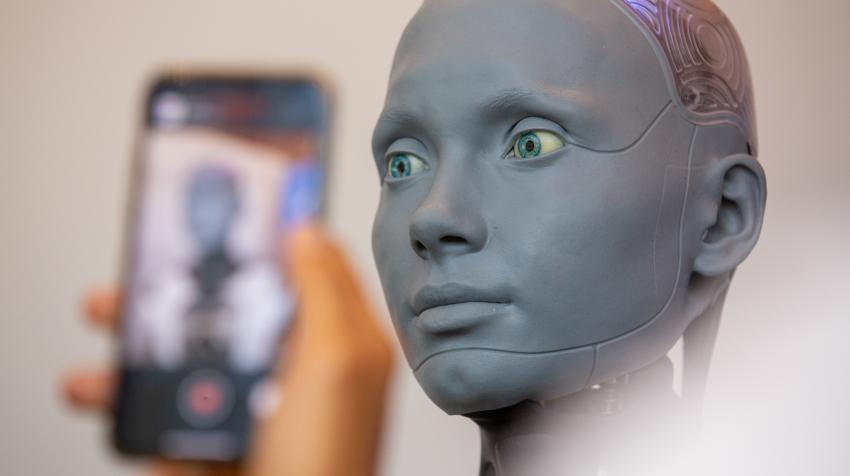 在“人工智能造福人类”全球峰会上，参观者正与机器人Ameca互动，摄于瑞士日内瓦，2023年7月。联合国图片/Elma Okic