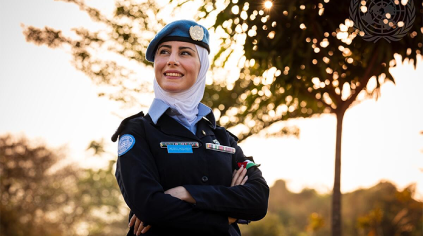 A uniformed peacekeeper smiles and poses for a photo.