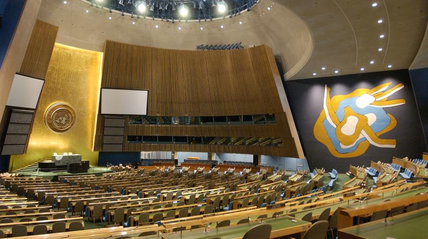 Overview of the General Assembly Hall and the light orange, light blue, and white mural from the left side of the chamber.