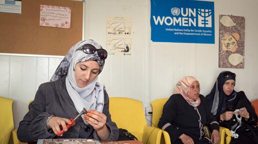 Three women participating in a mosaic workshop led by UN Women. 