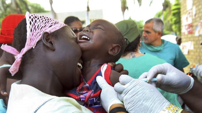 A mother comforts her child as he receives vaccinations by the World Health Organization. 