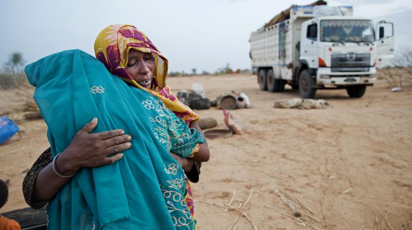 Two women are hugging each other emotionally as they return to their hom village in Sudan after living seven years in an Internally Displaced Persons camp.  