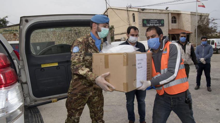 Major Stefano Parisi (left) of UNIFIL helps hand over equipment and other accessories to Naqoura Municipality in south Lebanon as part of the mission’s effort to assist local communities fighting the COVID-19 pandemic. 31 March 2020. UN/Pasqual Gorriz.