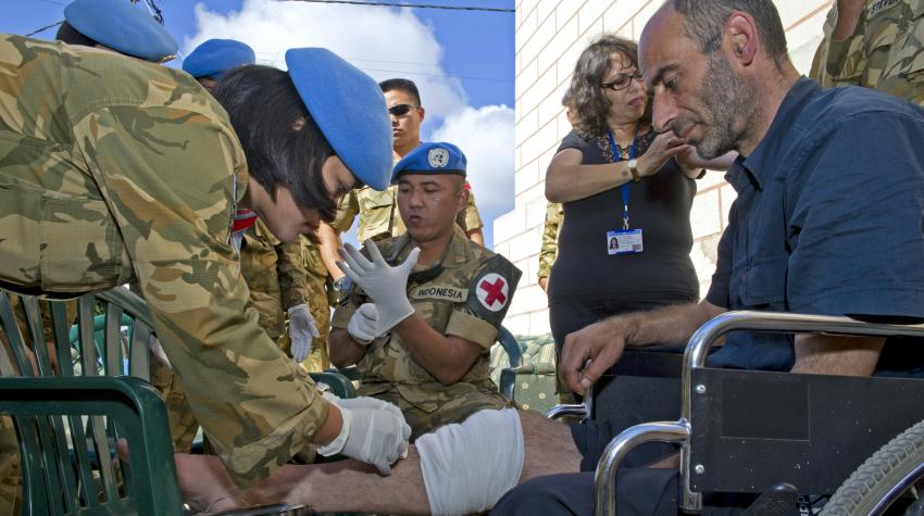 The medical team of the Indonesian contingent is treating a car accident patient's injured knee. 