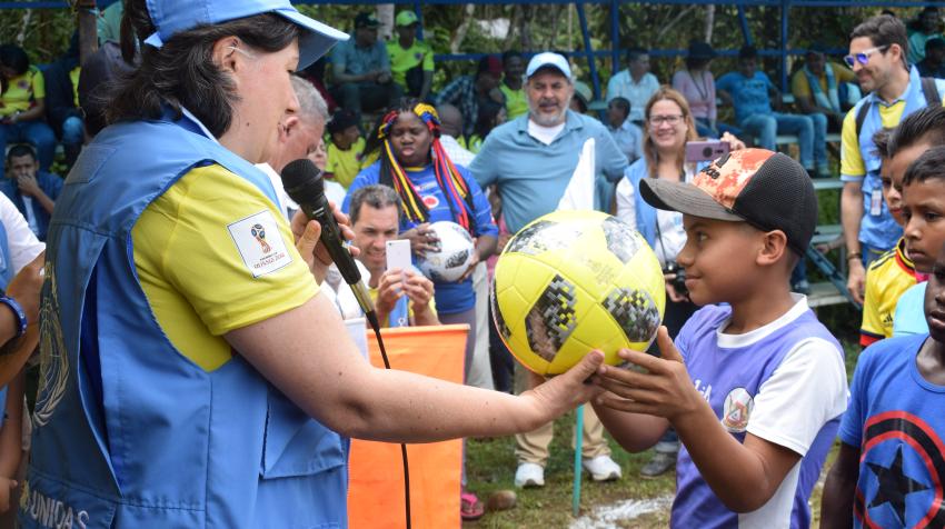 在由联合国哥伦比亚核查团组织的前哥人民军战斗人员和哥伦比亚武装力量成员之间的比赛上，一名哥伦比亚达贝巴的居民受赠一个足球。摄于2018年6月19日。联合国图片/Jennifer Moreno Canizales。
