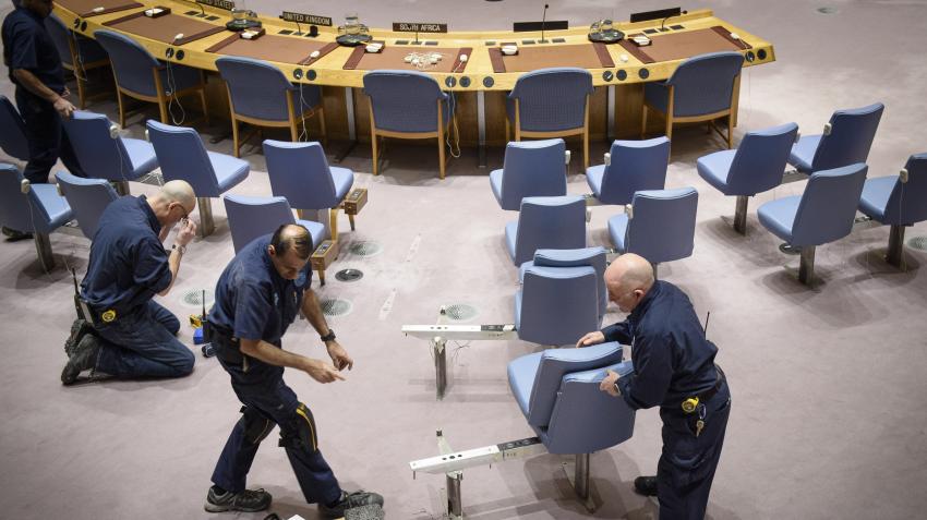 Le personnel du Service de gestion des installations retire des chaises dans la salle du Conseil de sécurité pour permettre à un délégué d’utiliser un fauteuil roulant. New York, 28 février 2019. Photo ONU/Loey Felipe