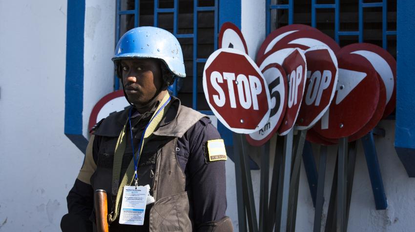 A blue helmet UN police stands guard as the delegation visits Haiti. 