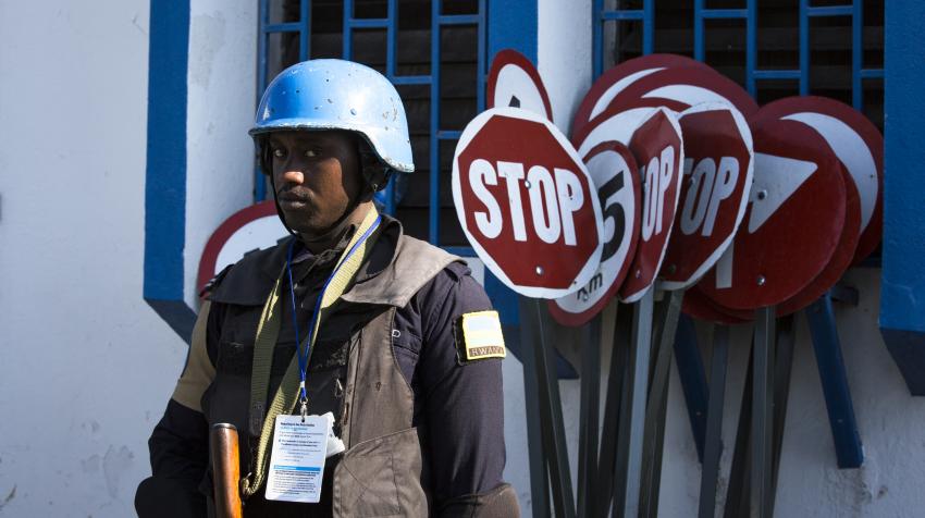 A blue helmet UN police stands guard as the delegation visits Haiti. 