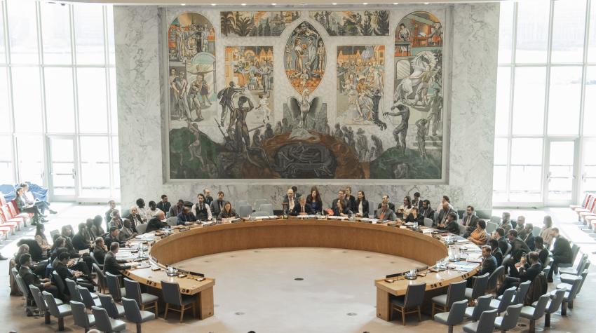 General view of the Security Council chamber with a round table for delegations and wall mural of a pheonix.  