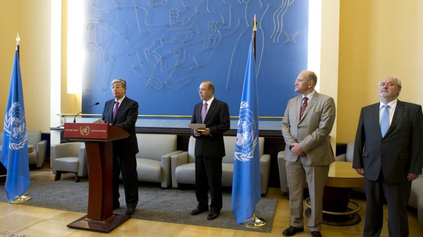 Person speaking on podium in front of large wall with blue artwork in the lounge. 