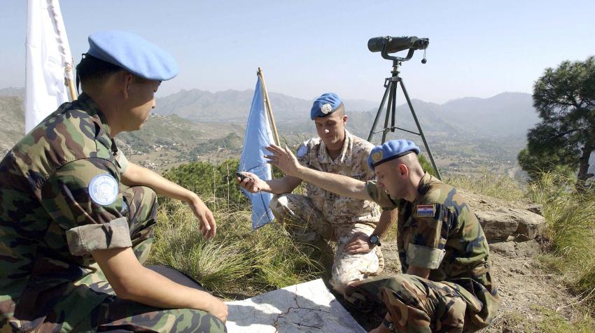 Three peacekeepers are going over their plans near the UN field station in Pakistan 