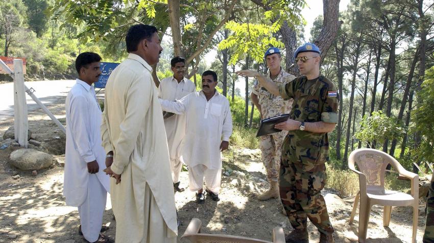 Two peacekeepers are speaking with local Pakistani men.