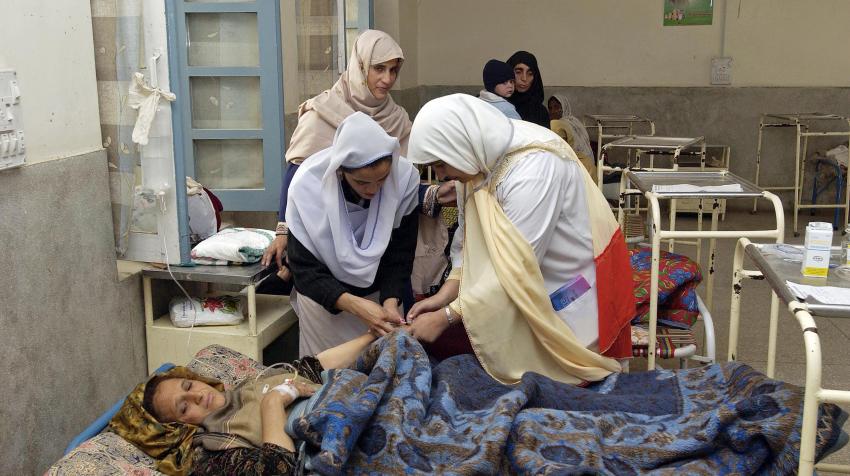 A woman who had given birth two hours earlier and is a victim of the earthquake that hit Pakistan, is being treated in a hospital by several other women. 