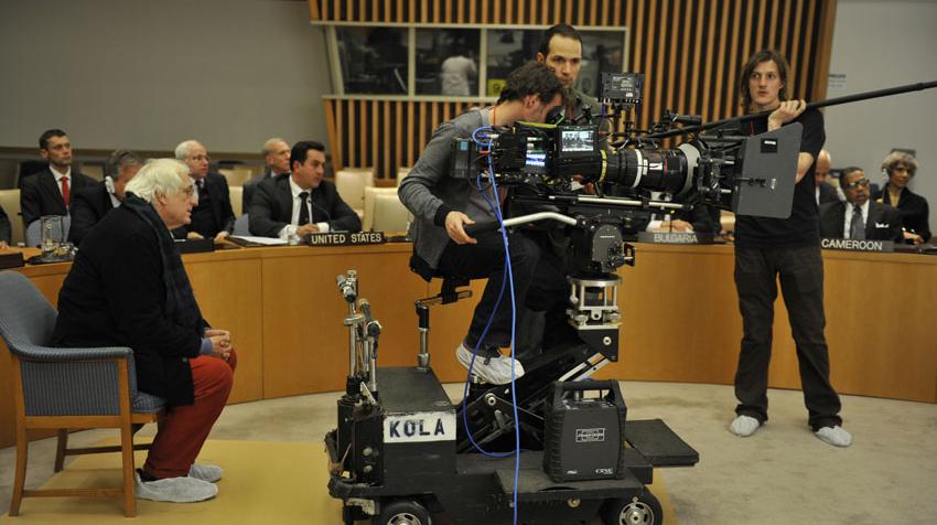 Picture of filming crew in the Security Council chamber with the director behind the cameraman.  