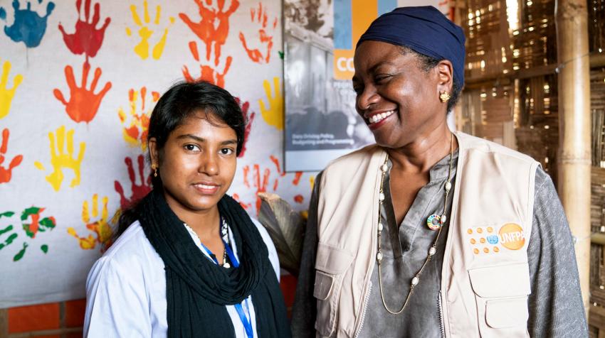 Dr. Natalia Kanem looks, with a tender smile, at a midwife standing next to her.