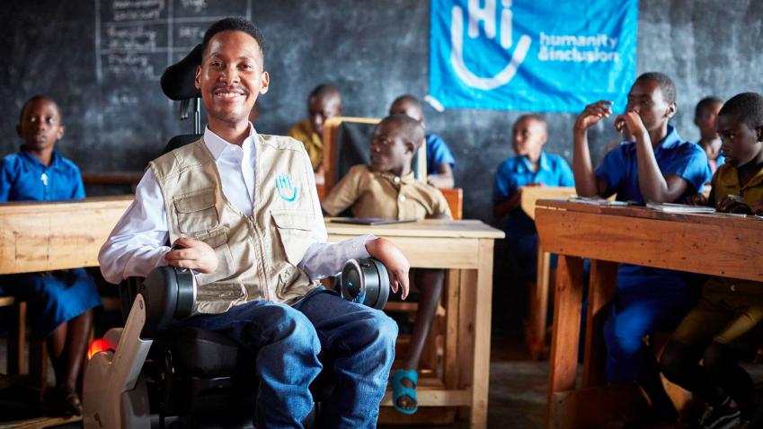 Eddie in his wheelchair at a class with children behind him