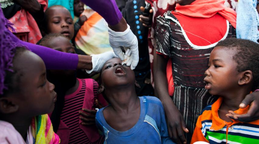 Una enfermera de la Visión Mundial administra la vacuna de la poliomielitis facilitada por la Organización Mundial de la Salud (OMS) a niños desplazados que residen en la base de la Operación Híbrida de la Unión Africana y las Naciones Unidas en Darfur (U