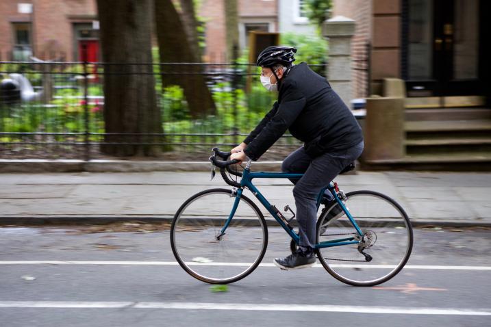 A bicyclist wearing a mask.