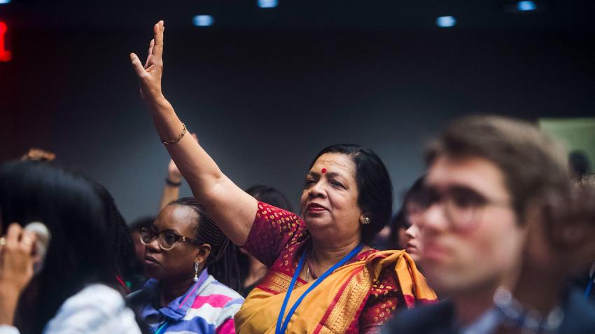 Women raising hand in crowd. 