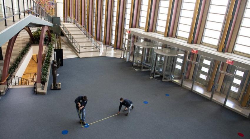 联合国人员在大会大楼的游客大厅里做标记，以实行人员流动管制，保持物理距离。
