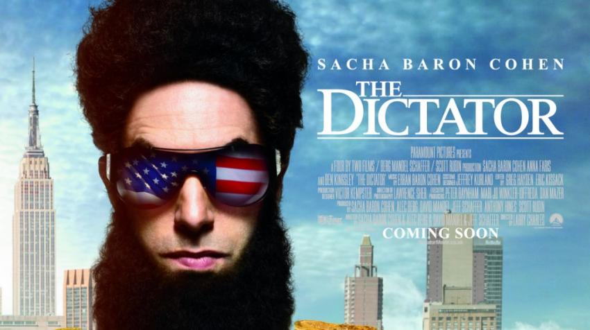 Movie poster of the actor with heavy beard and sunglasses with reflections of the US flag is on the left side of the picture, with the movie title, "The Dictator" on his right. 