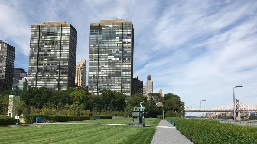 Green area near the East River, with statues from member states and pebbled trail. 