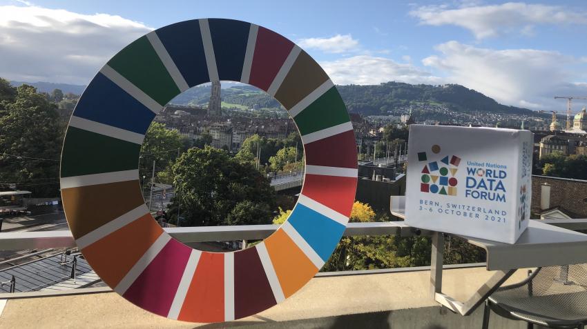 The SDG wheel and UN Data Forum logo are seen overlooking the panorama of Bern