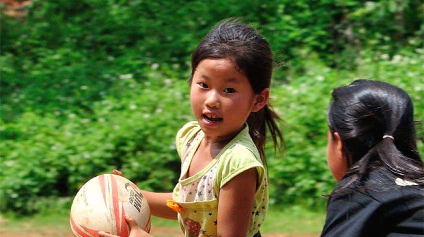 Dans le district de Nonghet, en République démocratique populaire lao, deux fillettes apprennent à jouer au rugby et développent leurs compétences nécessaires à la vie courante au moyen du programme Pass it Back, en 2015. © Lao Rugby Federation