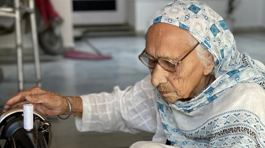 Mrs. Gurdev Kaur at her sewing machine, stitching masks for people in need. Moga, Punjab, India. April 2020. Photo by Ms. Raman Gill.