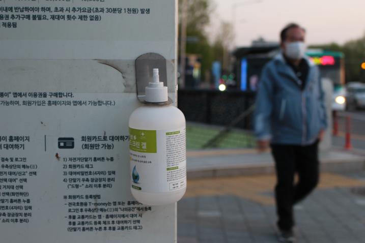 زجاجة من معقم اليدين متوفرة للاستخدام العام، ومرفقة بعلامة الاستشارة الصحية لجائحة كوفيد-19 في جمهورية كوريا. الصورة مقدمة من تابيثا كوون.