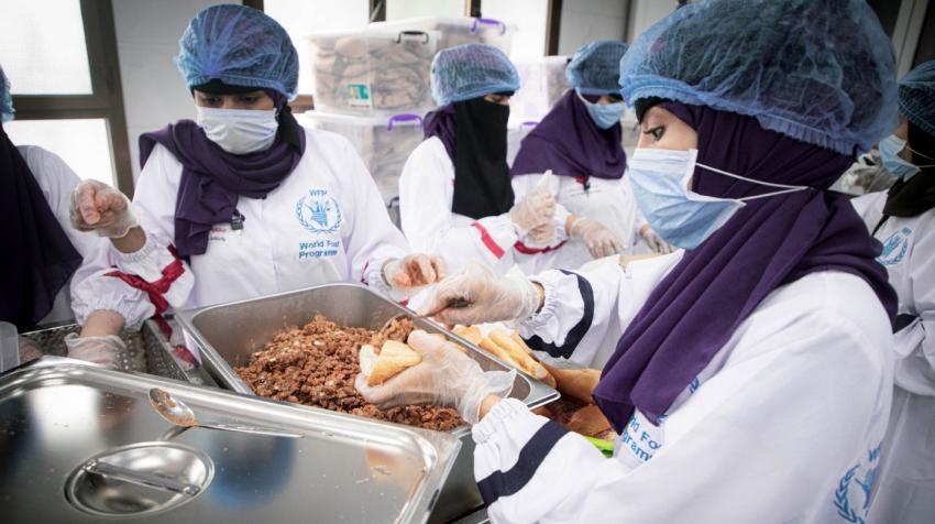 Mujeres preparando comidas con mascarillas