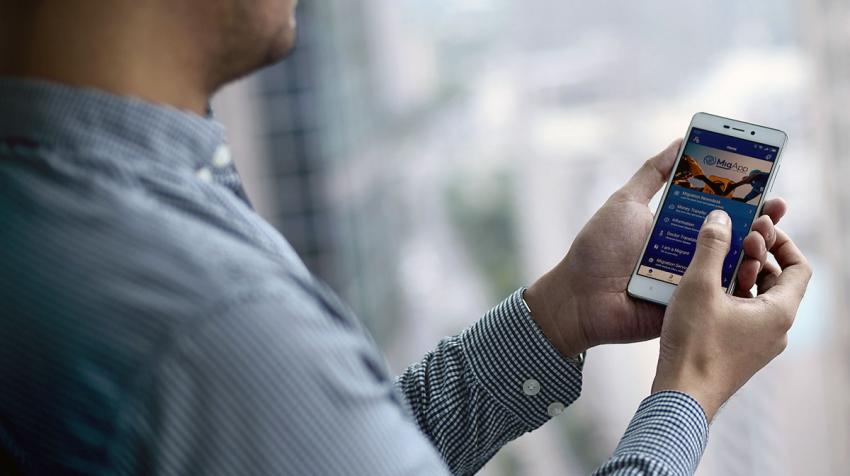 Un homme tient un mobile et regarde une application.